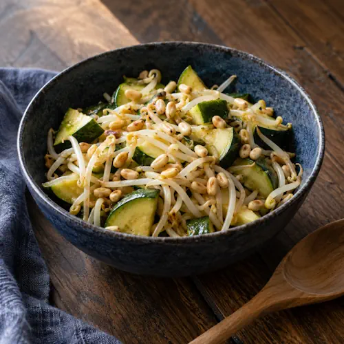 Gestoomde courgette met taugé, geroosterde pijnboompitten en een dressing van sojasaus, sesamolie en citroensap