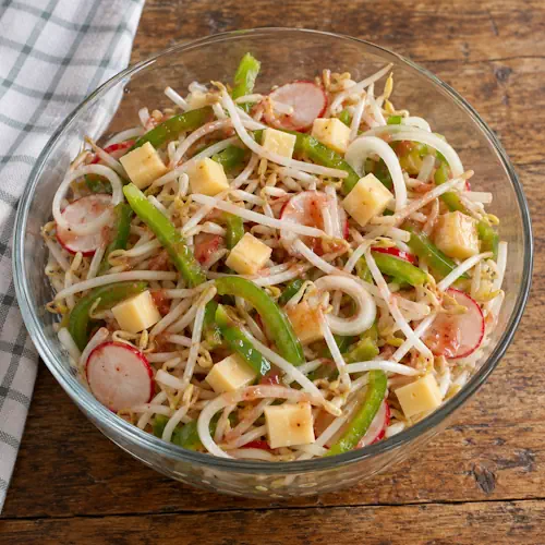 Taugésalade met groene paprika, radijs, ui, belegen kaas en een frisse ketchupdressing.